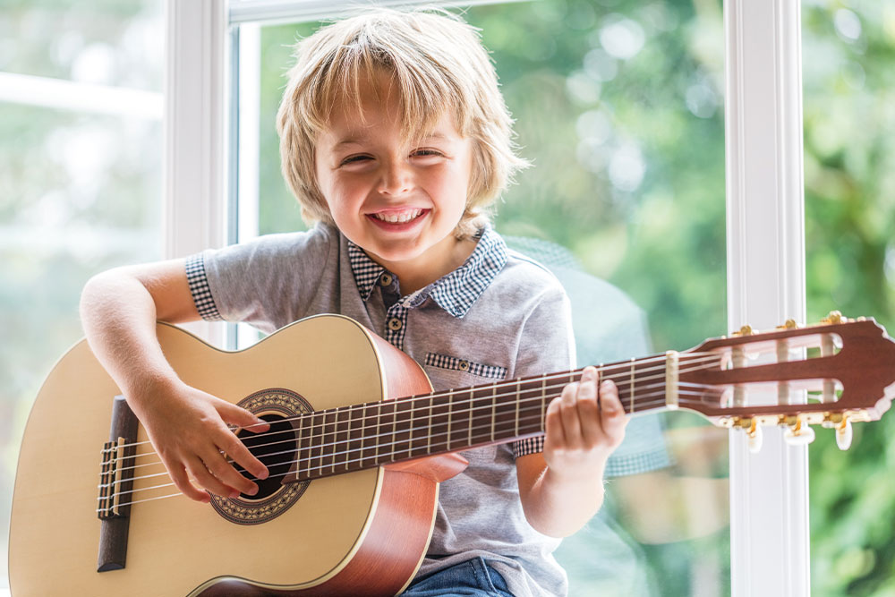 Das Bild der Musikschule Odenwald zeigt eine einfühlsame Musiklehrerin mit Kindern